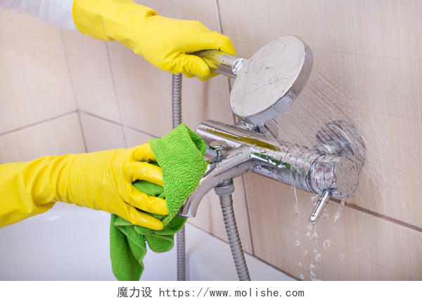 一位女士带着橡胶手套手拿淋浴头正清洗着浴室世界卫生日